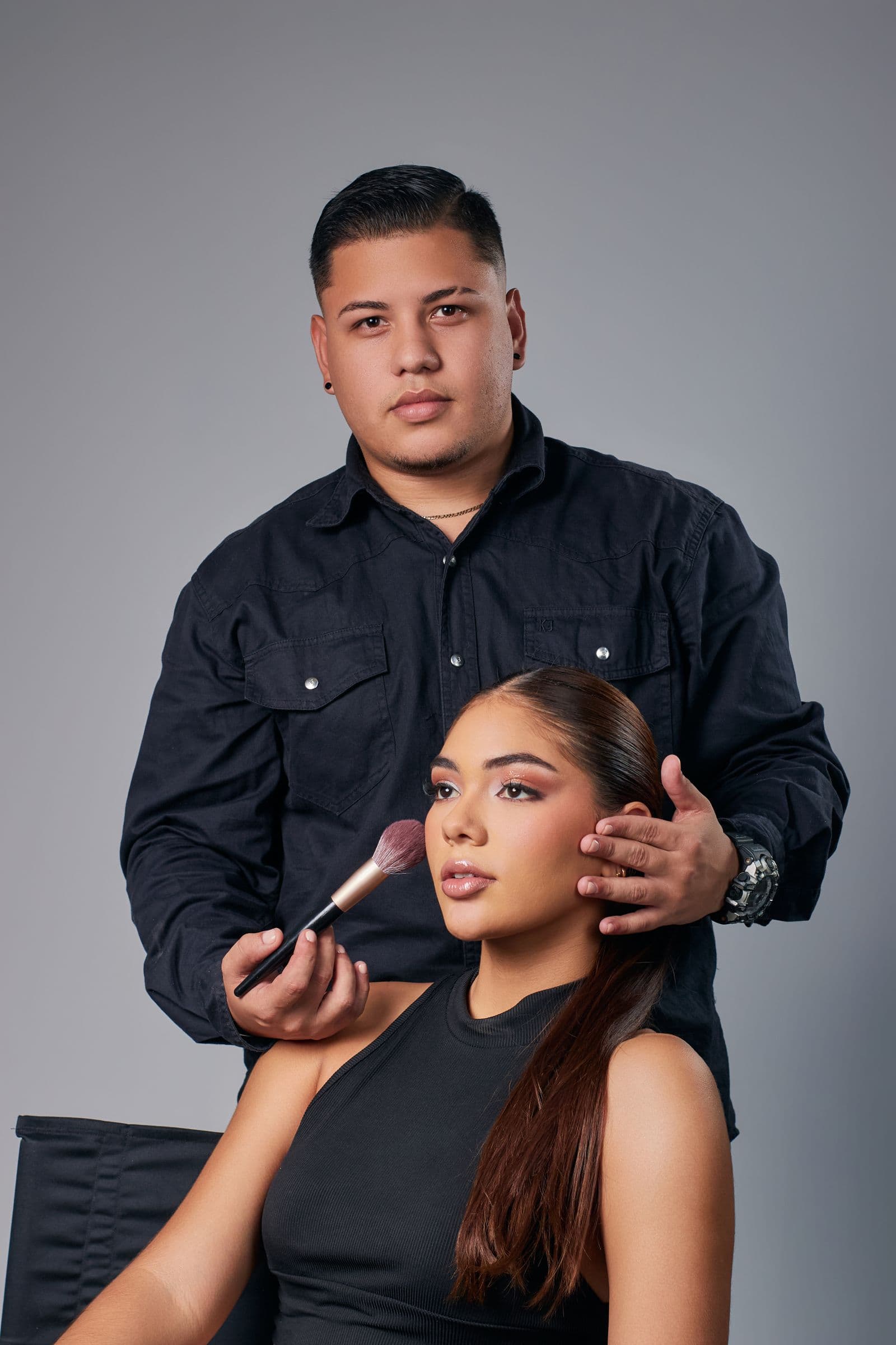 Beauty artist working on a client in a soft, natural-light studio.